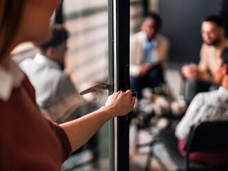 woman walking into room of people having discussion